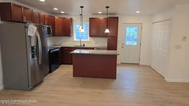 a kitchen with stainless steel appliances granite countertop a refrigerator a oven and a wooden floors