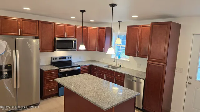 a kitchen with kitchen island a counter top space appliances and cabinets