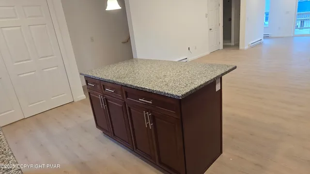 a utility room with granite countertop cabinets and sink
