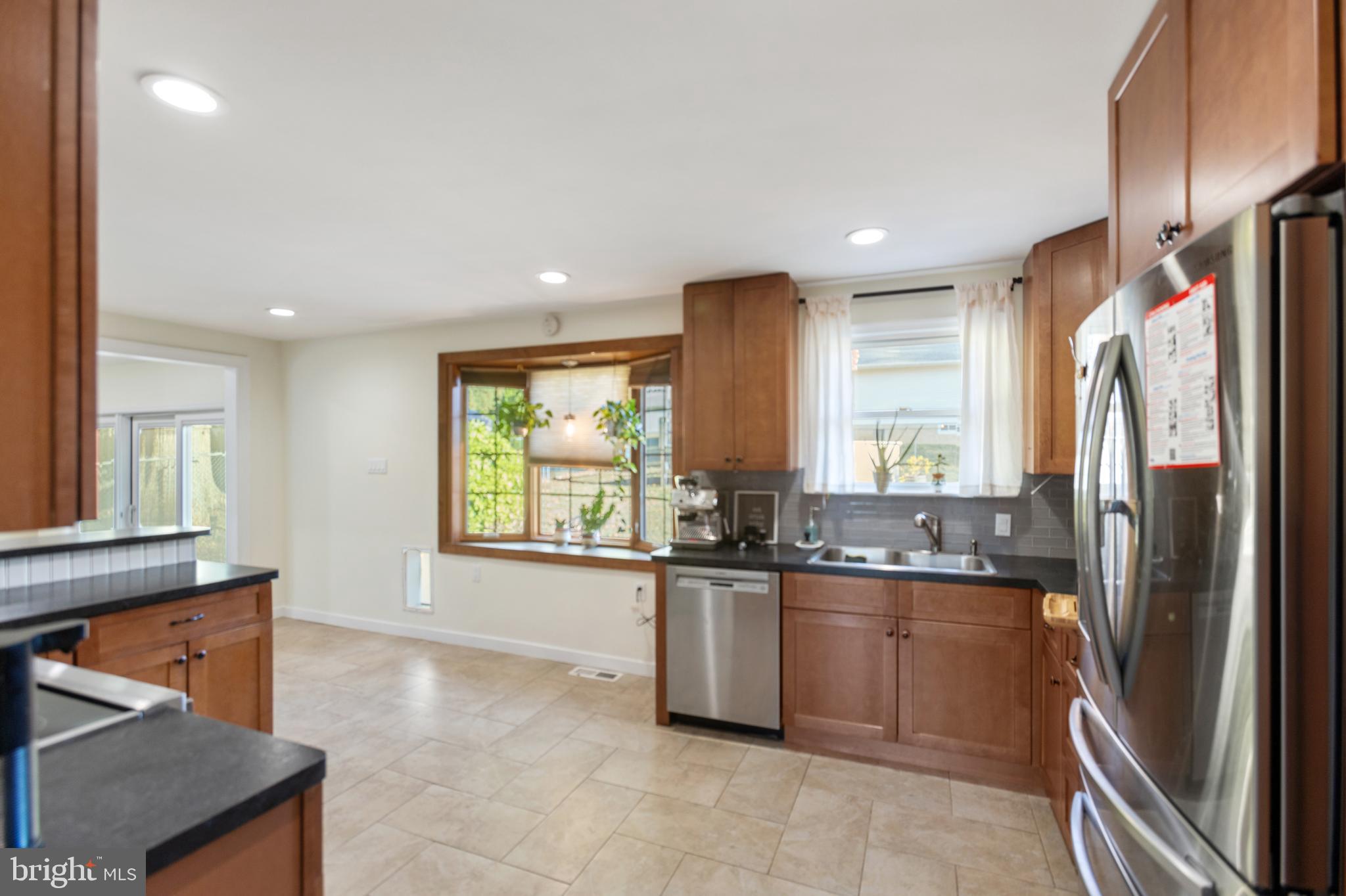 1801 North Hills Avenue Willow Grove, PA 19090 - Photo 10 of 20 a kitchen with stainless steel appliances granite countertop a refrigerator a sink a stove and white cabinets