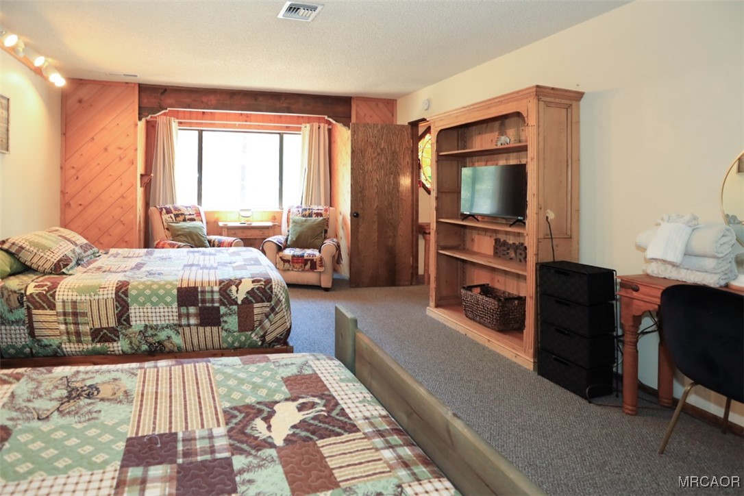 1201 Fox Farm Road Big Bear City, CA 92315 - Photo 11 of 16 a bedroom with a bed and a flat tv screen on dresser
