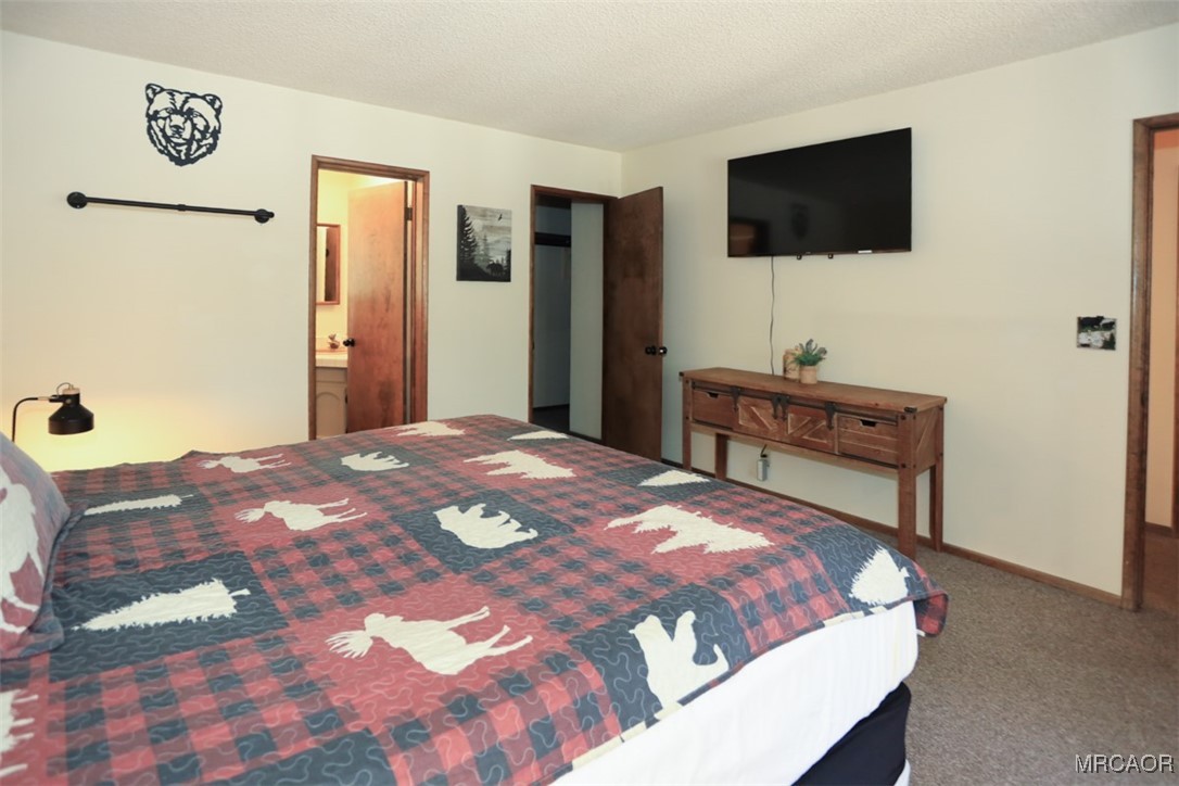 1201 Fox Farm Road Big Bear City, CA 92315 - Photo 8 of 16 a bedroom with a bed and a flat screen tv