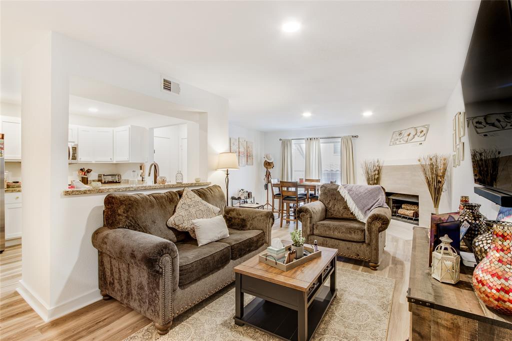 a living room with furniture a flat screen tv and kitchen view