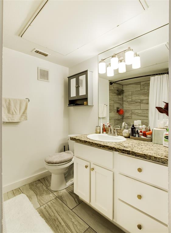 4777 Cedar Springs Road, Unit 7P Dallas, TX 75219 - Photo 21 of 28 a bathroom with a toilet a sink and mirror