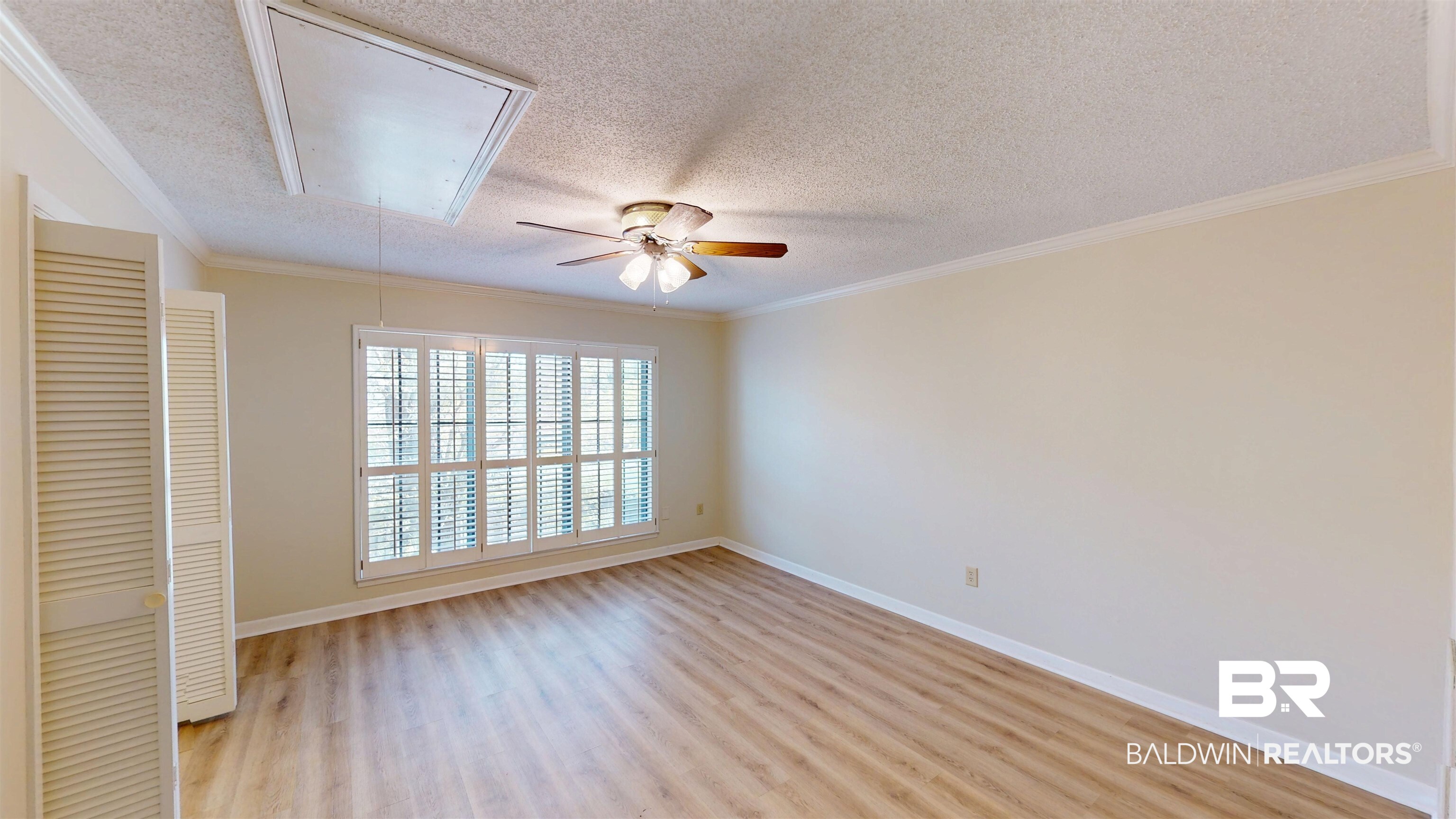 2901 Grant Street, Unit 902 Mobile, AL 36606 - Photo 14 of 35 Unfurnished room with light wood-style floors, a textured ceiling, crown molding, and ceiling fan