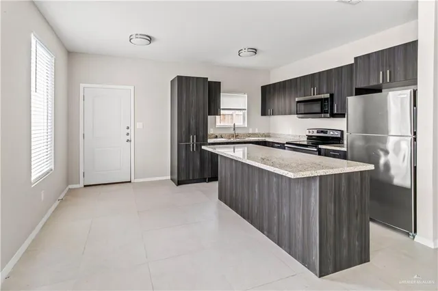 a kitchen with stainless steel appliances a refrigerator stove and microwave