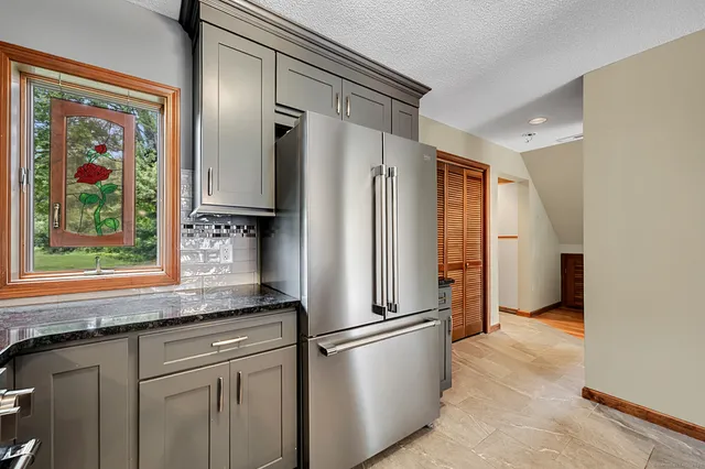 a kitchen with stainless steel appliances granite countertop a refrigerator and a sink