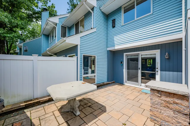 a view of a patio with table and chairs and wooden fence