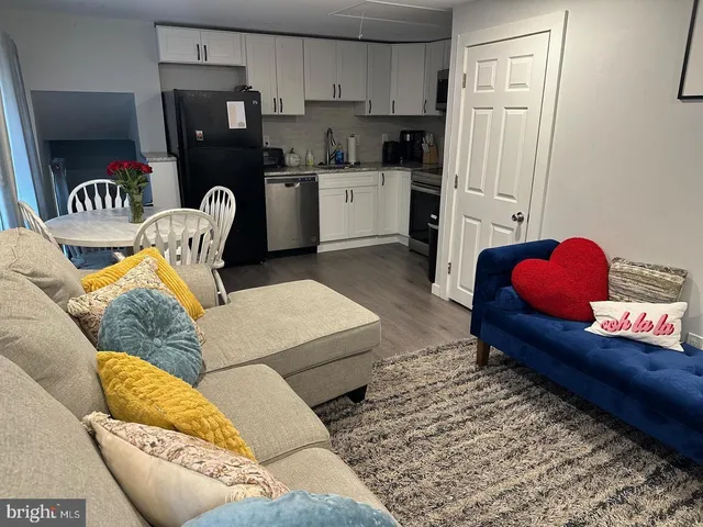 a living room with furniture and a refrigerator