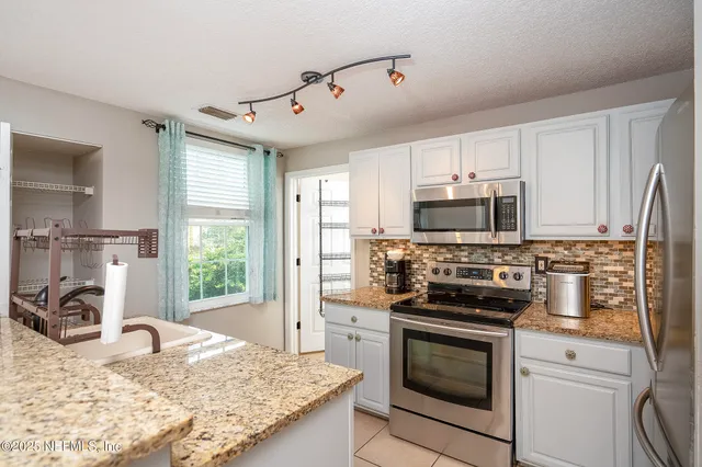 a kitchen with kitchen island granite countertop a stove sink and microwave