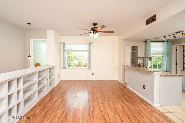 a view of an empty room with wooden floor and cabinet