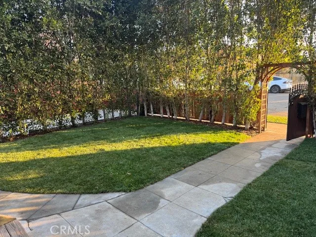 a backyard of a house with plants and large trees