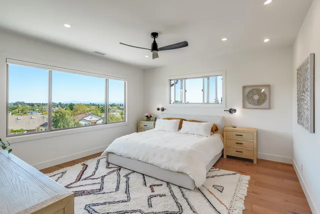 a bedroom with a bed and a large window