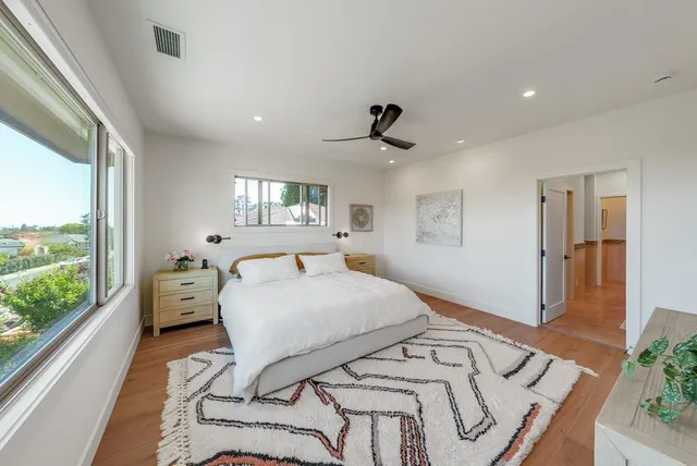 a spacious bedroom with a bed a table and a large window