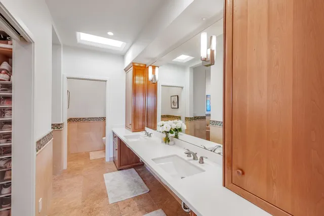 a en suite bathroom with a double vanity sink a mirror and a bathtub