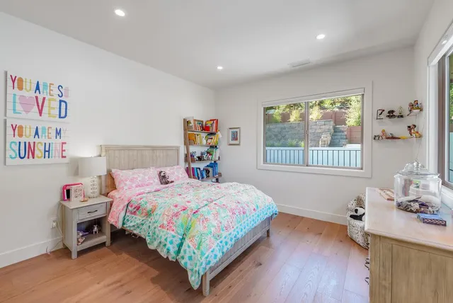 a bedroom with a bed table and a window