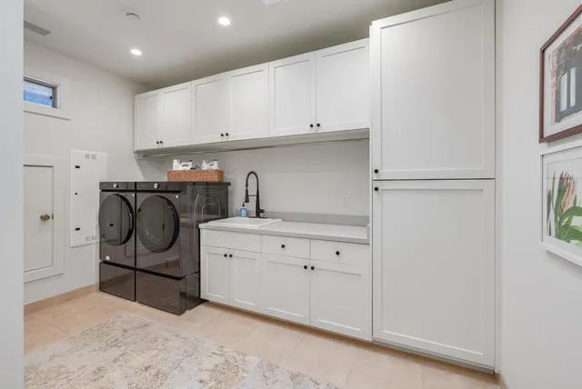 a utility room with cabinets washer and dryer