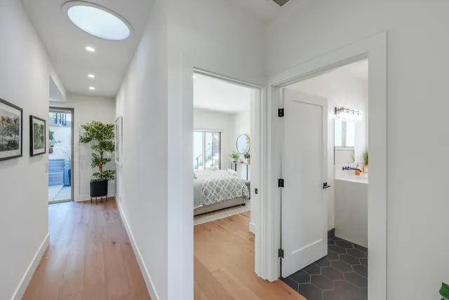 a view of a hallway with wooden floor and a bedroom