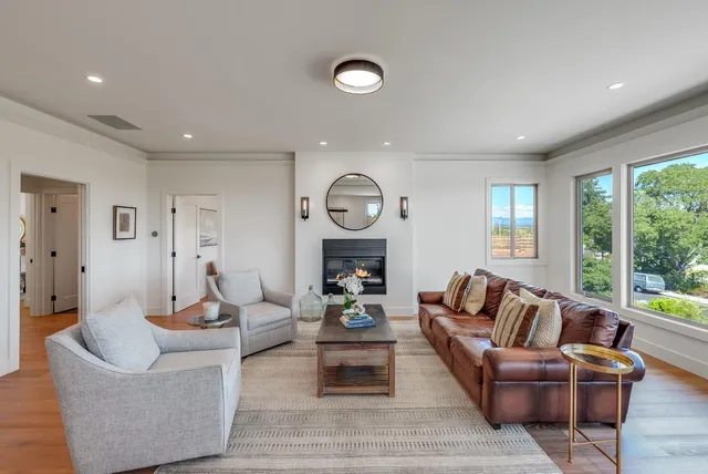 a living room with furniture chandelier and a large window