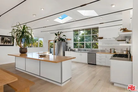 a large white kitchen with lots of counter space and window
