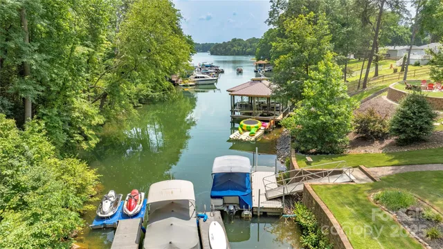 an aerial view of a house with swimming pool and lake view