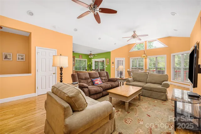a living room with furniture a ceiling fan and a flat screen tv