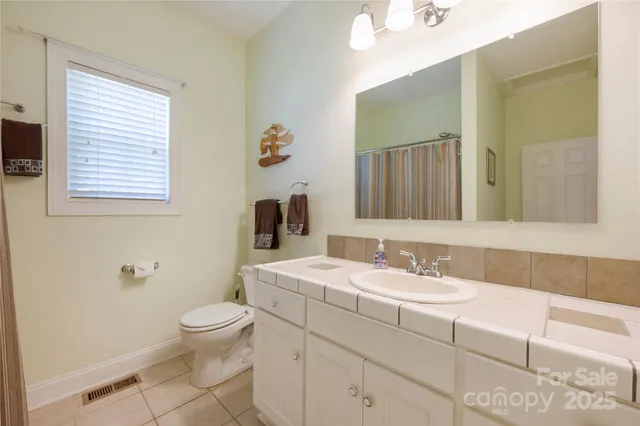 a bathroom with a sink a toilet and a mirror