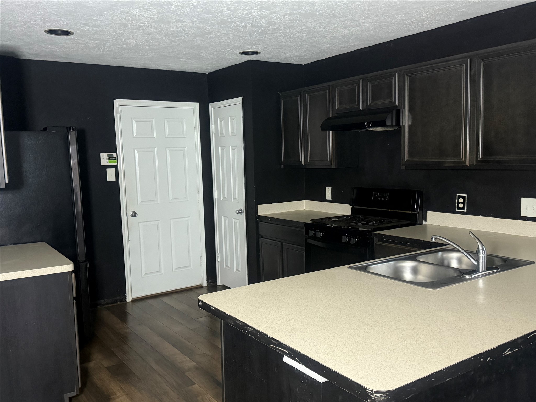 1119 Grassy View Drive Houston, TX 77073 - Photo 2 of 28 a kitchen with a sink a refrigerator and wooden cabinets