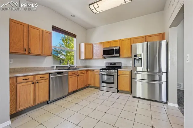 a kitchen with stainless steel appliances granite countertop a refrigerator sink and stove