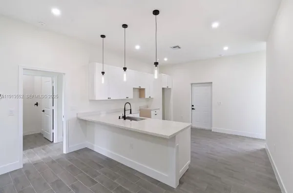 a view of a kitchen with a sink and refrigerator