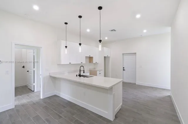 a view of a kitchen with a sink and refrigerator