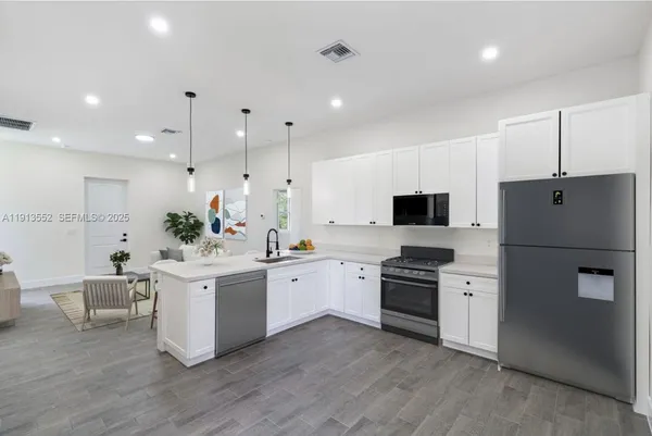 a kitchen with white cabinets and stainless steel appliances