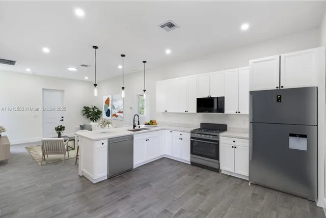 a kitchen with white cabinets and stainless steel appliances