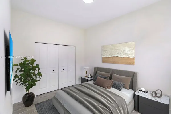 a bedroom with a large bed and a potted plant