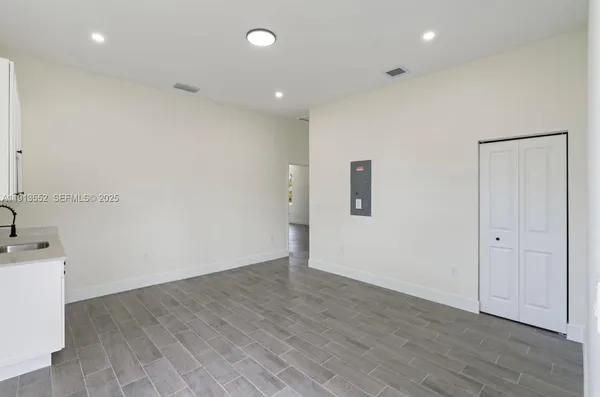 an empty room with wooden floor and mirror