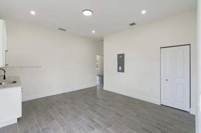 an empty room with wooden floor and mirror