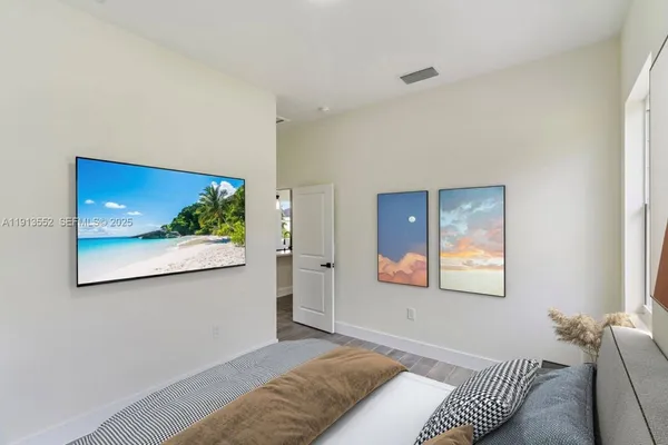 a bedroom with a bed and a painting on the wall