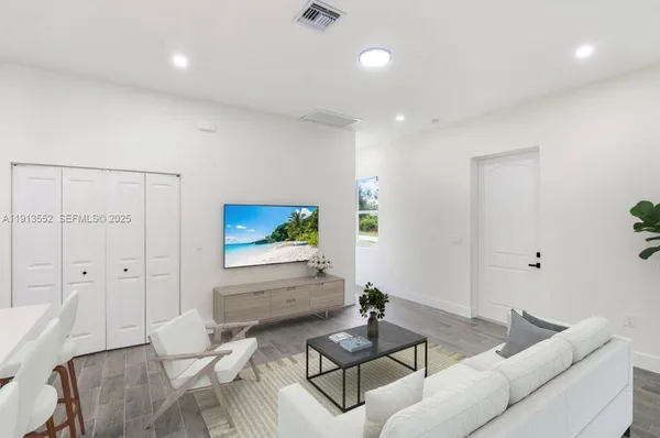 a living room with furniture a rug and a flat screen tv