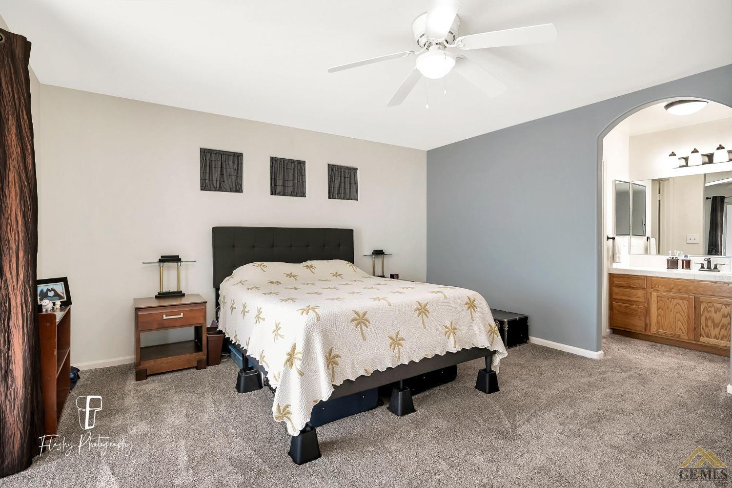 Undisclosed Address Bakersfield, CA 93308 - Photo 11 of 21 a spacious bedroom with a bed and a chandelier