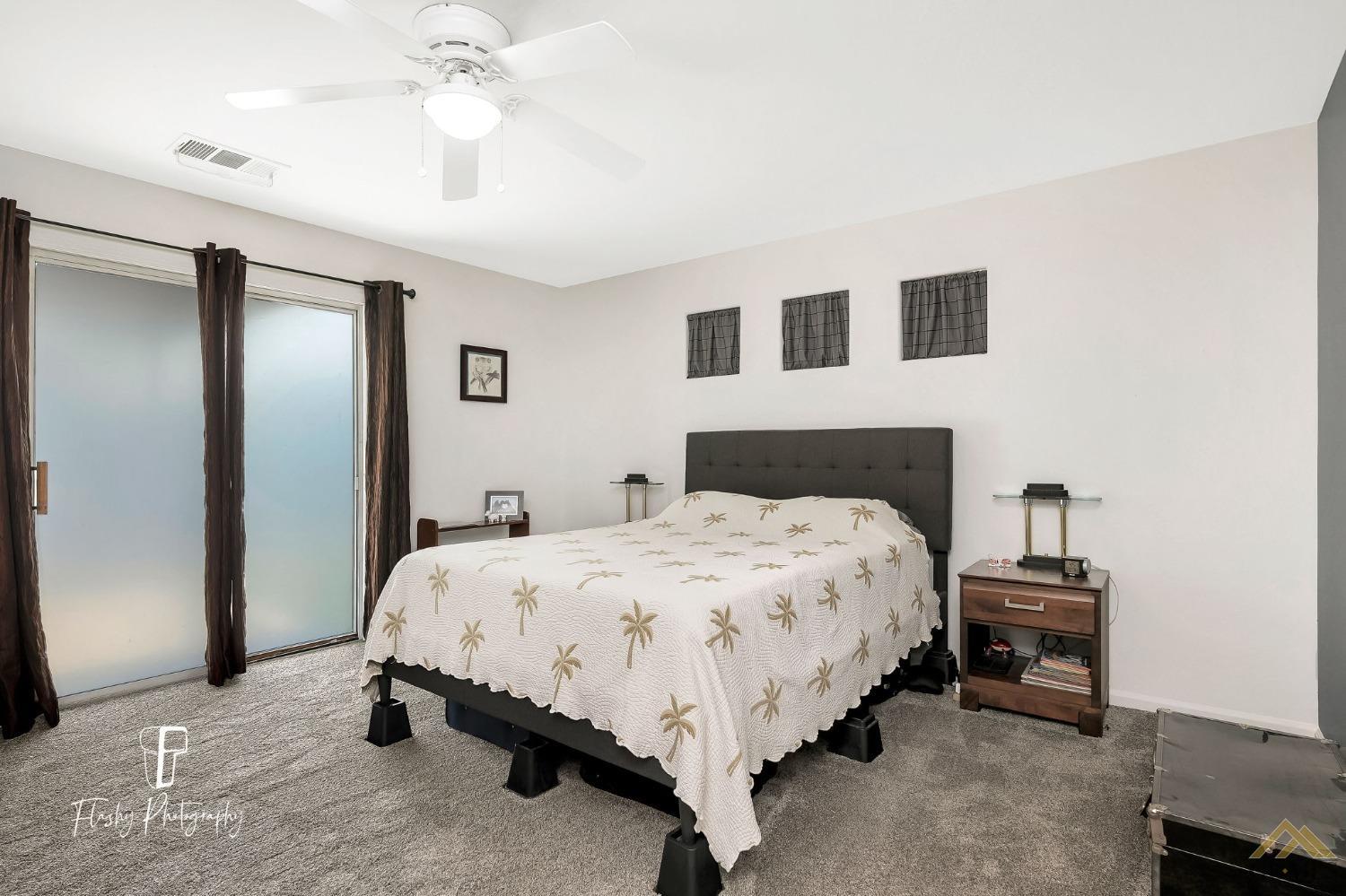 Undisclosed Address Bakersfield, CA 93308 - Photo 12 of 21 a spacious bedroom with a bed and a chandelier