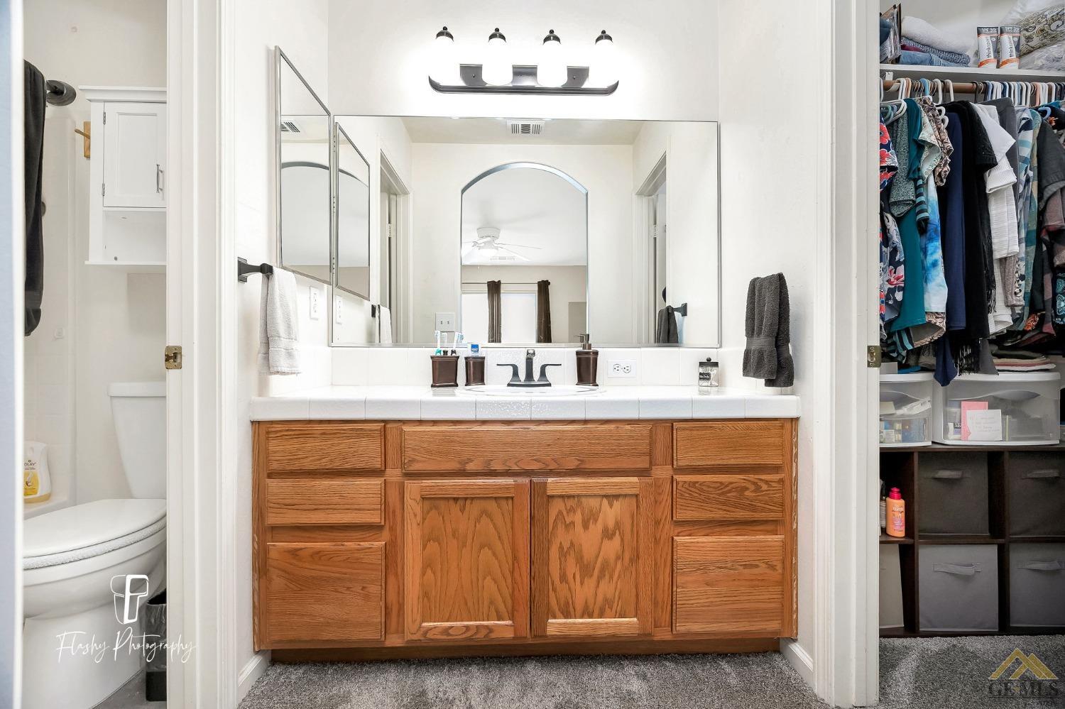 Undisclosed Address Bakersfield, CA 93308 - Photo 14 of 21 a bathroom with a double vanity sink and a mirror