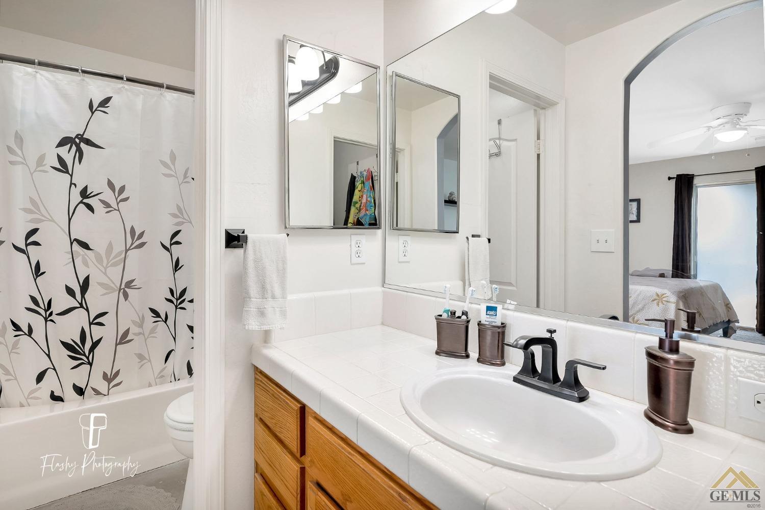 Undisclosed Address Bakersfield, CA 93308 - Photo 15 of 21 a bathroom with a bathtub sink and mirror