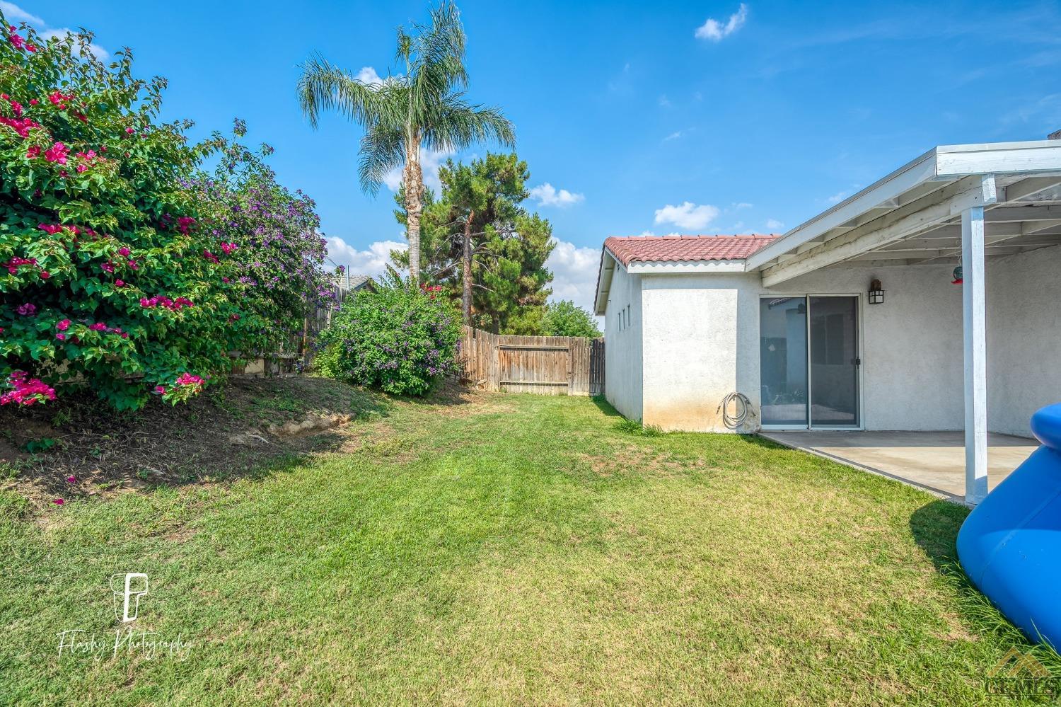 Undisclosed Address Bakersfield, CA 93308 - Photo 20 of 21 a view of a house with a yard and a garage