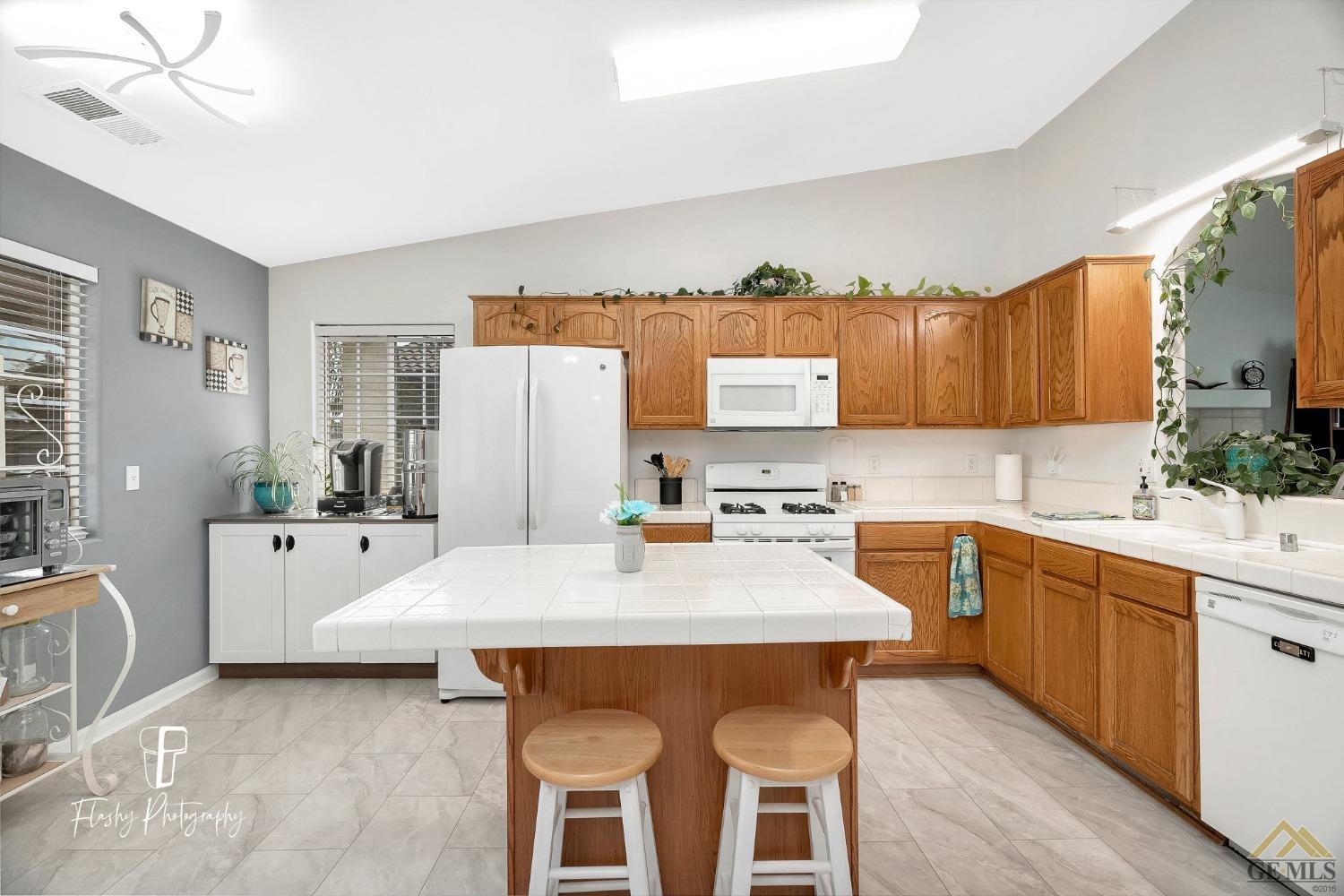 Undisclosed Address Bakersfield, CA 93308 - Photo 7 of 21 a large white kitchen with a table chairs and refrigerator