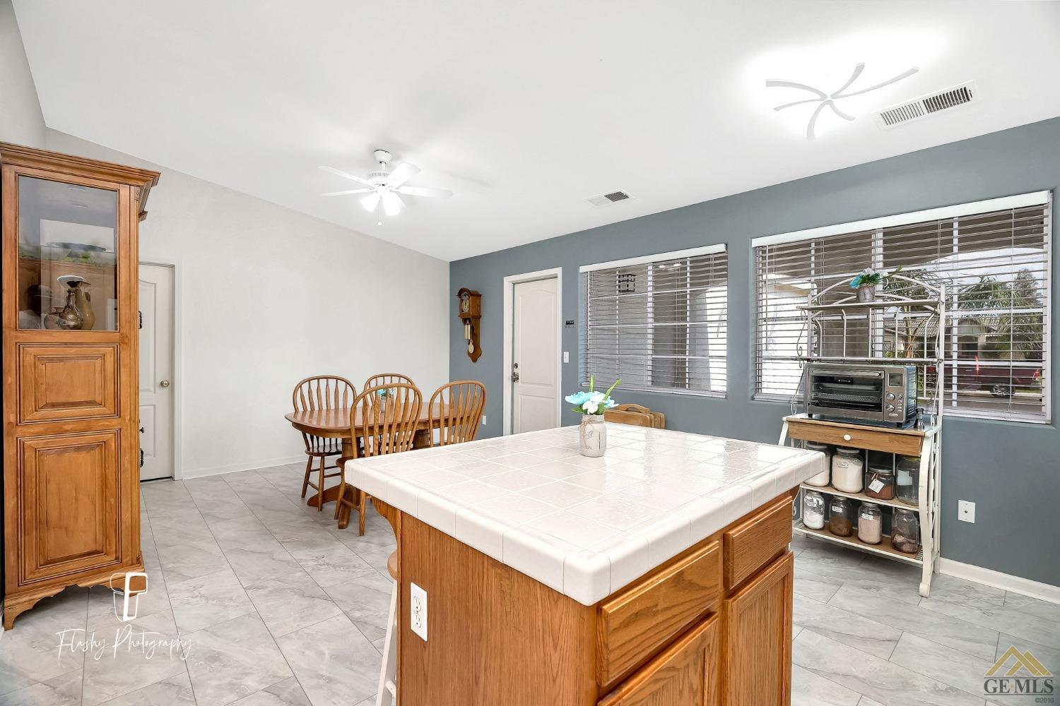Undisclosed Address Bakersfield, CA 93308 - Photo 8 of 21 a view of kitchen island with stainless steel appliances wooden floor and dining table