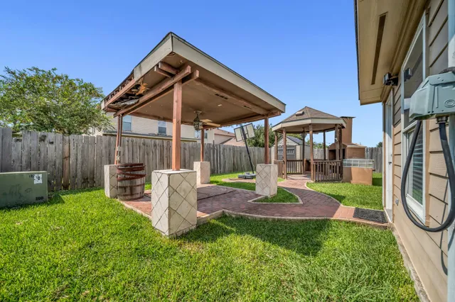 a view of a chair and table in backyard of the house