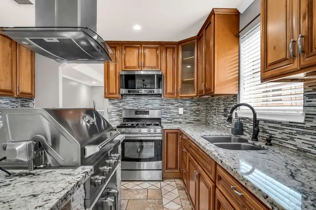a kitchen with stainless steel appliances granite countertop a sink stove and refrigerator