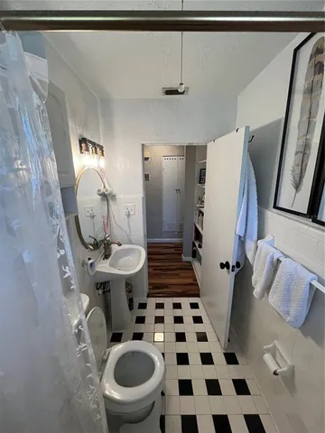 a bathroom with a sink a toilet and a mirror