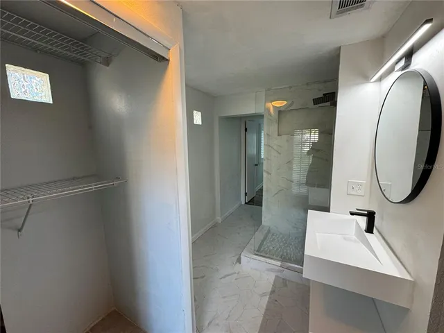 a bathroom with a sink mirror and shower