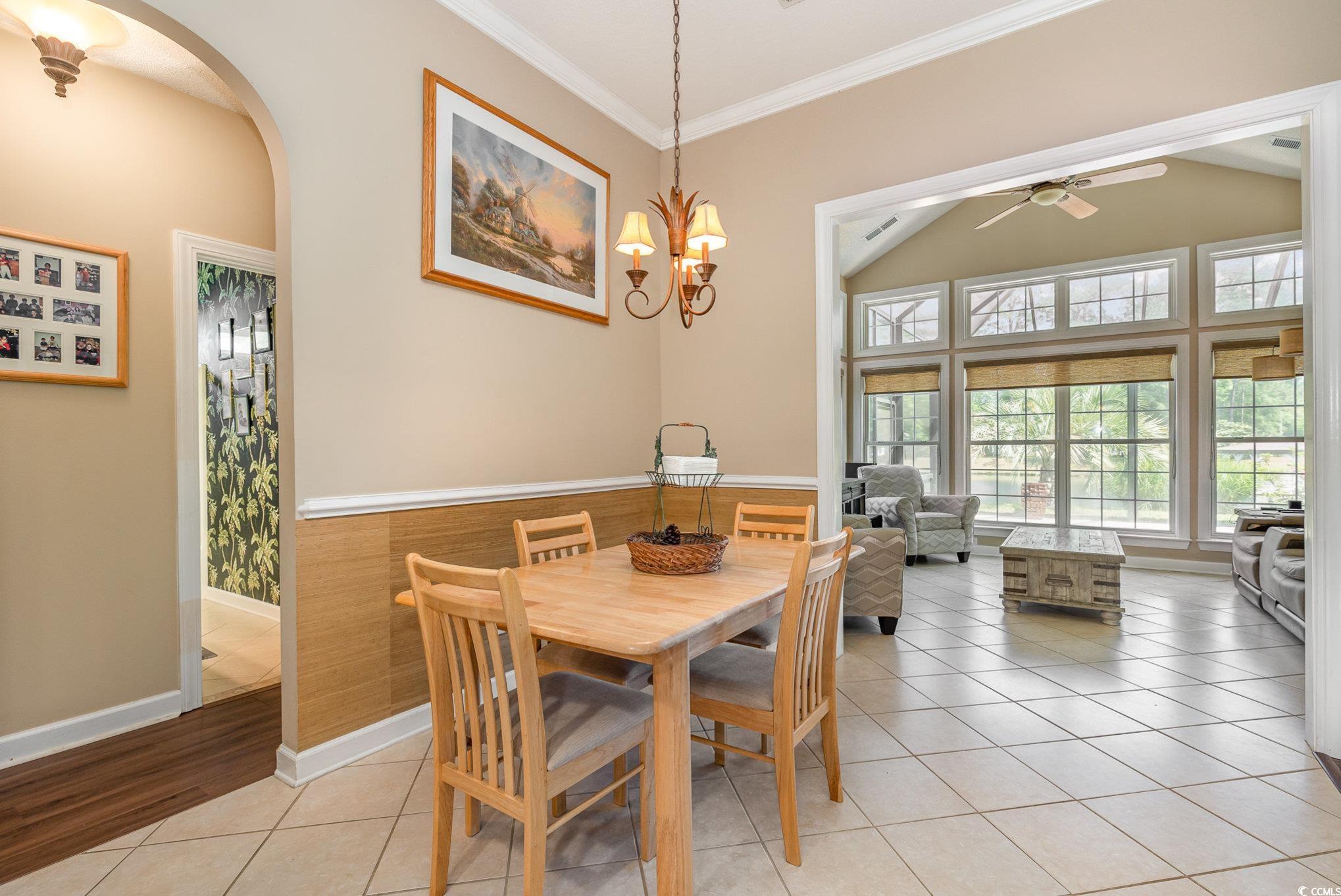 1004 Addington Court Murrells Inlet, SC 29576 - Photo 13 of 40 Dining room with a ceiling fan, arched walkways, crown molding, light tile patterned floors, and vaulted ceiling